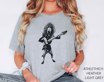 May include: Light grey t-shirt with a black graphic of a dog playing a guitar, wearing sunglasses and a jacket. The text "ATHLETHICH HEATHER LIGHT GREY" is printed on the right side of the shirt.