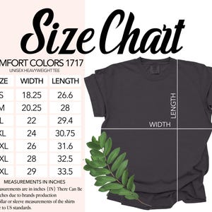 May include: A dark gray Comfort Colors unisex heavyweight tee shirt with a size chart. The chart lists sizes S to 4XL, with width and length measurements in inches. A sprig of green leaves is in the lower left corner.