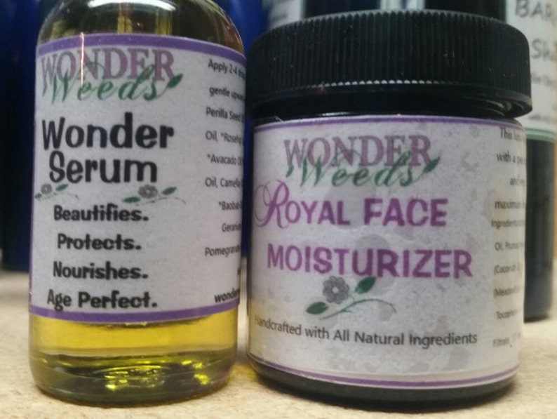 Puede incluir: Dos botellas de vidrio con etiquetas blancas. La botella de la izquierda est&aacute; etiquetada como "Wonder Weeds Wonder Serum" y enumera los beneficios del suero: Embellece, Protege, Nutre, Perfecciona la edad. La botella de la derecha est&aacute; etiquetada como "Wonder Weeds Royal Face Moisturizer" e indica "Elaborado artesanalmente con ingredientes totalmente naturales".