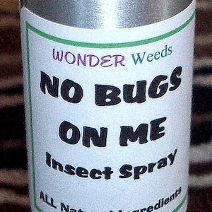 May include: A silver spray bottle with a black cap and a white label that reads "WONDER Weeds NO BUGS ON ME Insect Spray ALL Natural Ingredients".