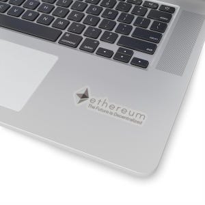 Pode incluir: Um computador portátil prateado com um adesivo branco no canto superior direito. O adesivo apresenta um logotipo Ethereum cinza e o texto "ethereum The Future is Decentralized".