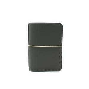 Peut inclure: Un journal en cuir gris foncé avec une fermeture élastique crème. Le journal a des coins arrondis et des coutures blanches sur les bords. La couverture est lisse et minimaliste, adaptée à l'écriture ou au croquis.