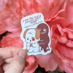 May include: A sticker featuring a sad cartoon dog with brown and white markings, being controlled by a dark brown ghost. The sticker has the text "I AM THE VOICE INSIDE YOUR HEAD AND I CONTROL YOU".