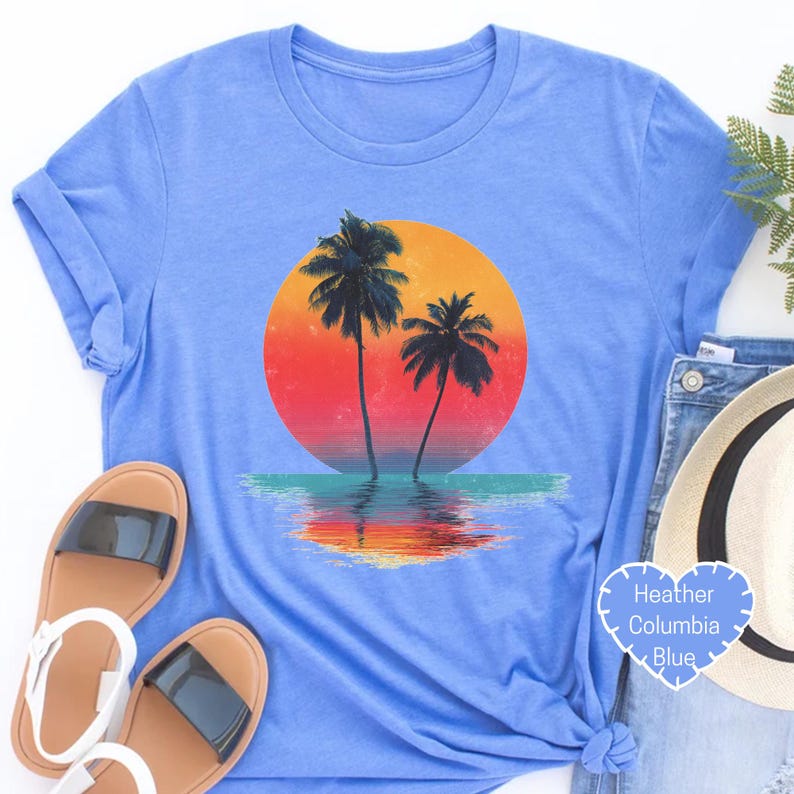 a blue shirt with a sunset and two palm trees