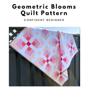 May include: A white quilt with a geometric pattern of pink and orange squares and diamonds. The quilt is labeled "Geometric Blooms Quilt Pattern" and "Confident Beginner". The quilt has a black and white striped border.