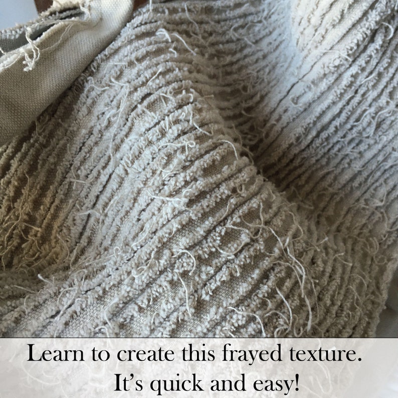 May include: Close-up of a light grey fabric with a frayed texture. The fabric has a ribbed pattern and is made of a soft, fuzzy material.