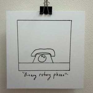 Puede incluir: Una impresión cuadrada blanca que presenta un dibujo lineal en tinta negra de un teléfono de disco con un solo dial circular que contiene dos puntos. El texto "Binary rotary phone" está escrito a mano en tinta negra debajo del dibujo.