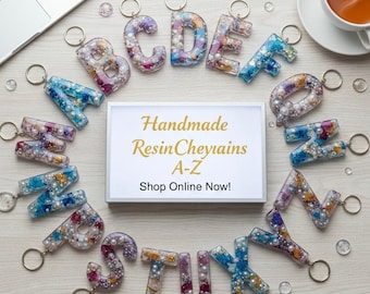 May include: Handmade resin keychains in the shape of the alphabet letters A-Z. Each letter is filled with colorful accents and pearls. The keychains are arranged around a sign that reads "Handmade ResinCheyains A-Z Shop Online Now!"
