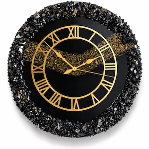May include: A circular wall clock with a black face and gold Roman numerals. The clock features a central gold band of textured glitter and a thick border of jagged, dark black crystalline stones. It has two gold hands indicating the time.