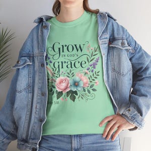 Może przedstawiać: Jasnozielony t-shirt z kwiatowym wzorem i tekstem "Grow in God's grace" z odniesieniem do Pisma Świętego "Peter 3:18".