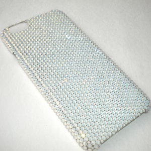 May include: A white phone case covered in iridescent white rhinestones.