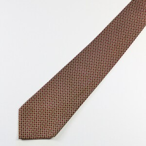 May include: A red patterned tie with a geometric design in gold. The tie is made of a smooth fabric.