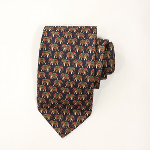May include: A navy blue silk tie with a repeating pattern of brown elephants with red, green, and gold accents.