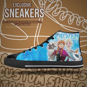 Puede incluir: Zapatillas altas con suela y cordones negros. El lienzo azul presenta personajes de la pel&iacute;cula "Frozen" y la palabra "FROZEN". Tambi&eacute;n se ve el texto "EXCLUSIVE SNEAKERS" y "CUSTOM-MADE".