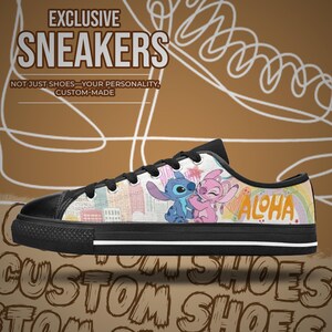Op de afbeelding: Zwarte en witte lage sneakers met een kleurrijk ontwerp met stripfiguren en het woord "ALOHA". De schoenen hebben een zwarte neus en zool, met de tekst "EXCLUSIVE SNEAKERS" op de bovenkant.
