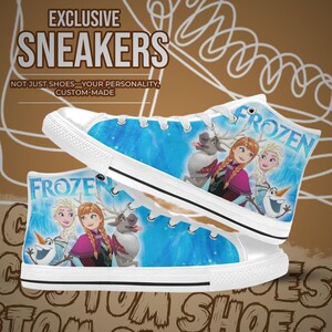 Puede incluir: Zapatillas altas blancas con un dise&ntilde;o azul y blanco de Frozen. Las zapatillas presentan la palabra "FROZEN" e im&aacute;genes de personajes de la pel&iacute;cula. El texto "EXCLUSIVE SNEAKERS" est&aacute; en la parte superior de la imagen, con el texto "NOT JUST SHOES - YOUR PERSONALITY, CUSTOM-MADE" debajo.