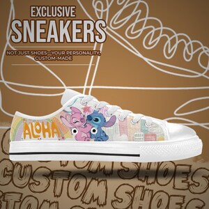 Op de afbeelding: Witte canvas sneakers met een kleurrijk ontwerp met de personages Stitch en Angel, met het woord "ALOHA". De schoenen hebben witte veters en een witte rubberen zool. De tekst "EXCLUSIVE SNEAKERS" staat bovenaan.