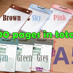 K&ouml;nnte beinhalten: A5-Tagesplaner in Braun, Himmelblau und Pink mit insgesamt 100 Seiten. Die Planer haben einen Kunstlederbezug und sind 15,2 cm breit und 21,7 cm hoch. Zus&auml;tzliche Planer in Cyan, Gr&uuml;n und Grau sind ebenfalls abgebildet.