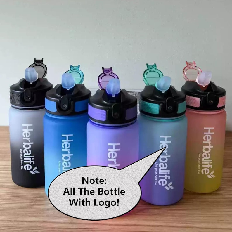 May include: Five colorful water bottles with a black lid and a straw. Each bottle has a gradient design and the Herbalife logo with the text "Live your best life". The bottles are on a wooden surface. Note: All The Bottle With Logo!