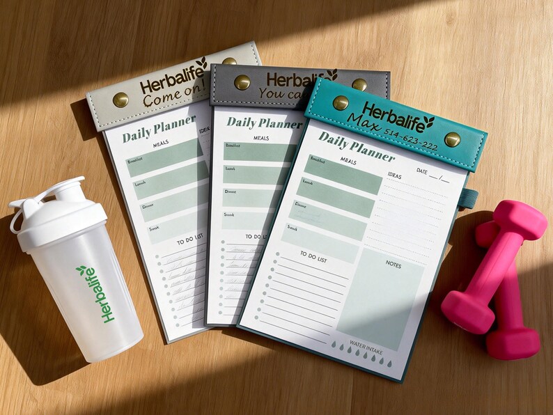 K&ouml;nnte beinhalten: Ein Set aus drei Keramikbechern mit einer gesprenkelten, cremefarbenen Glasur. Jeder Becher hat ein anderes handgemaltes Design: ein blaues und gr&uuml;nes Blatt, eine gelbe Blume und eine rote Beere. Die Becher haben eine einfache, abgerundete Form und einen bequemen Griff.