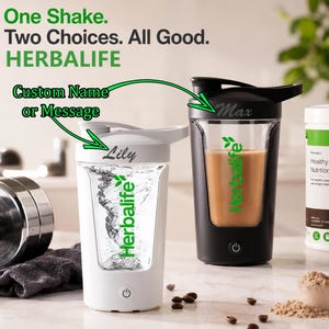 Può includere: Due shaker elettrici, uno bianco e uno nero, ciascuno con il logo verde Herbalife e un nome personalizzato, Lily e Max, stampato sul coperchio. Il testo One Shake. Two Choices. All Good. HERBALIFE appare sopra gli shaker.