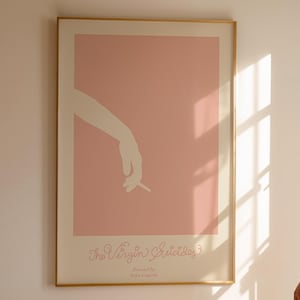 Puede incluir: Un vestido blanco de diseño sencillo cuelga de una persona en una habitación con un póster rosa y blanco en la pared. El póster tiene una mano blanca sosteniendo un cigarrillo.