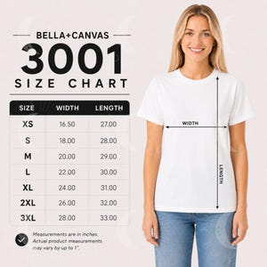 Pode incluir: Uma tabela de tamanhos Bella+Canvas 3001 com as medidas de largura e comprimento em polegadas para os tamanhos de XS a 3XL. Uma t-shirt branca apresenta setas que indicam os pontos de medição para a largura e o comprimento.