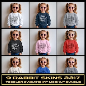 May include: A grid of nine toddler sweatshirts in various colors, including white, navy, gray, black, pink, and red. Each sweatshirt features the text "Your Design Here". The image is labeled "9 RABBIT SKINS 3317 TODDLER SWEATSHIRT MOCKUP BUNDLE".