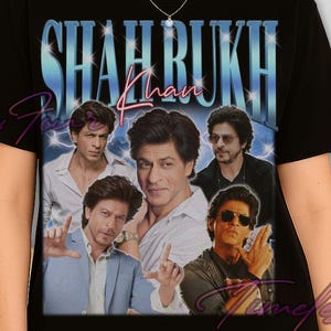 Puede incluir: Camiseta negra con un collage de Shah Rukh Khan y el texto "Shah Rukh Khan" en degradado azul y blanco. El diseño tiene un aspecto vintage y descolorido.