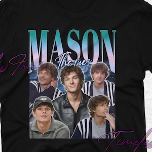 May include: Black t-shirt featuring a graphic of Mason Thames with the text "MASON Thames" in a gradient font. The design includes multiple images of the actor. The shirt is a classic crew neck style.