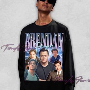 May include: Black sweatshirt featuring a collage of images of Brendan Fraser, with the name "Brendan Fraser" in a stylized font. The design includes lightning bolt graphics and a vintage aesthetic, perfect for fans.