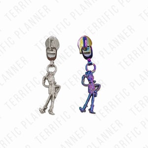 May include: Two silver zipper pulls with a rainbow iridescent finish. Each pull features a cartoon cowboy figure with a hat and a gun.