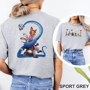 K&ouml;nnte beinhalten: Sportgraues T-Shirt mit einem farbenfrohen Aufdruck von Figuren aus einem beliebten Zeichentrickfilm. Auf der R&uuml;ckseite des Shirts ist eine gro&szlig;e blaue Schlange zu sehen, die sich um einen Fuchs und ein Kaninchen windet. Der Text "SPORT GREY" steht unten.