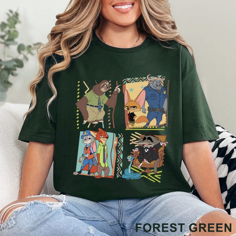May include: Forest green t-shirt with a vibrant graphic of cartoon characters in square panels. The shirt has the words "FOREST GREEN" printed at the bottom. The design includes a sloth, fox, and other animal characters.