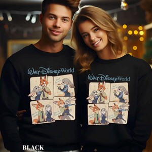 Puede incluir: Sudaderas negras con un dise&ntilde;o de dibujos animados de un zorro y un conejo de la pel&iacute;cula Zootr&oacute;polis. Las sudaderas tienen el texto "Walt Disney World" en escritura azul en la parte superior. La parte inferior de la sudadera tiene la palabra "BLACK" en letras blancas.