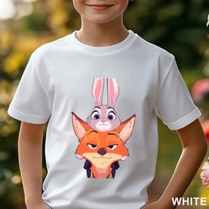 May include: White t-shirt with a cartoon fox and rabbit design. The fox is orange, and the rabbit is grey with pink ears. The word "WHITE" is printed in white at the bottom right corner of the shirt.
