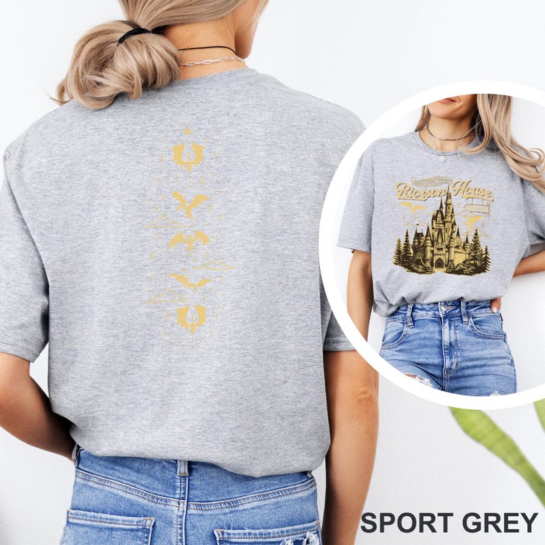 May include: Sport grey t-shirt with a gold castle graphic and the text "Rivera House". The back of the shirt has a vertical gold design. The shirt is worn with blue jeans.