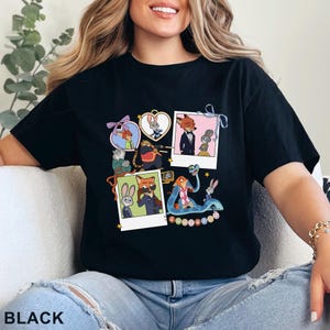 May include: A black t-shirt featuring a graphic print of various Zootopia characters in heart-shaped frames and polaroid-style photos. The design includes Nick Wilde and Judy Hopps in multiple scenes, along with other characters, and the word Zootopia.