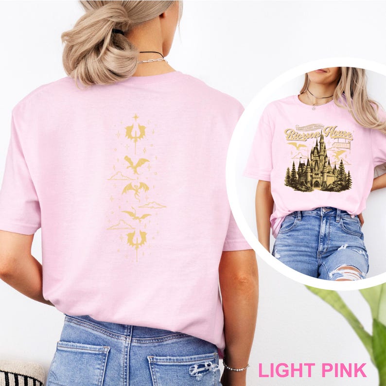 May include: Pale pink t-shirt with a gold dragon design on the back and a castle graphic with the text "Raven House" on the front. The shirt is a light pink colour and is made of a soft material.