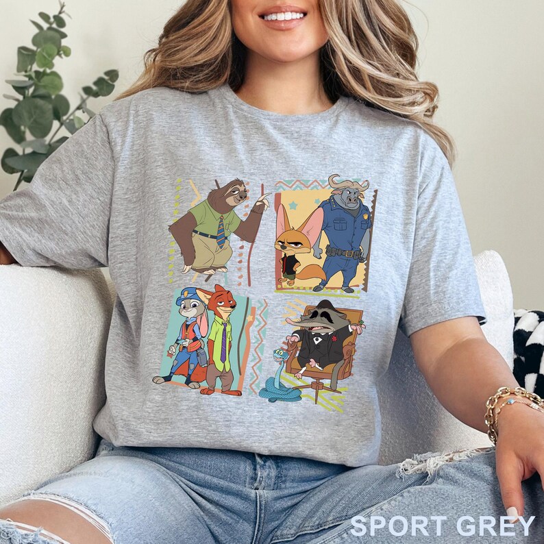 May include: A grey t-shirt with a colourful graphic of characters from the animated film Zootropolis. The design includes images of a sloth, a fox, a buffalo, a rabbit, a fox, and a rat. The words "SPORT GREY" are printed at the bottom.