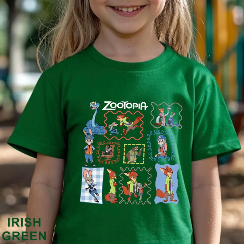 K&ouml;nnte beinhalten: Ein kurz&auml;rmeliges smaragdgr&uuml;nes T-Shirt mit einem Grafikdruck verschiedener Charaktere aus dem Film Zootopia. Das Design enth&auml;lt mehrere gerahmte Illustrationen von Tieren, darunter ein Fuchs und ein Hase, mit dem Text Zootopia.