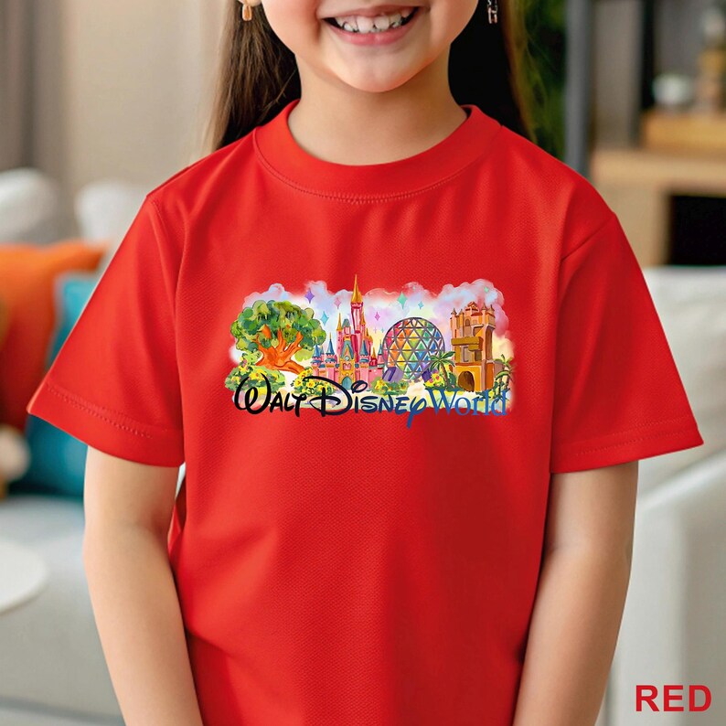 May include: A bright red short-sleeved t-shirt featuring a colorful graphic print of the Walt Disney World theme park landmarks, including the castle and geodesic sphere, with the text Walt Disney World printed in a dark blue script font.