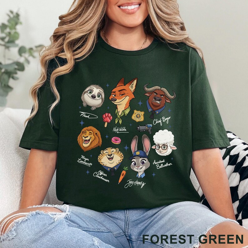 Puede incluir: Una camiseta de color verde bosque oscuro con un estampado gr&aacute;fico de varios personajes animales animados, incluyendo un zorro, conejo, perezoso, le&oacute;n, guepardo, b&uacute;falo y oveja, junto con peque&ntilde;os iconos como un donut, una zanahoria y una placa.