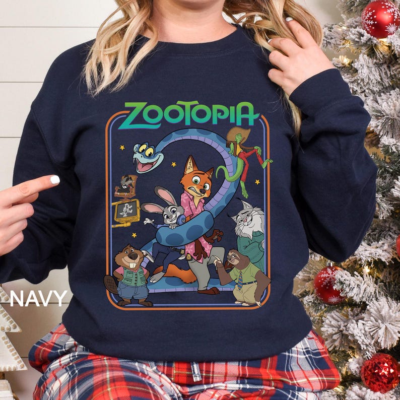 Pu&ograve; includere: Felpa blu navy con una grafica colorata del film d'animazione Zootropolis. Il design include il titolo del film e vari personaggi, come Judy Hopps, Nick Wilde e Flash. La parola "NAVY" &egrave; stampata sul lato sinistro della felpa.