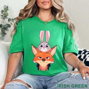 May include: Green t-shirt with a cartoon illustration of a fox and a rabbit. The fox is orange and the rabbit is grey with pink ears. The text "IRISH GREEN" is at the bottom of the image.
