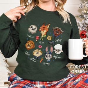 May include: Forest green sweatshirt featuring cartoon characters from Zootopia. The design includes Flash, Nick Wilde, Chief Bogo, Mayor Lionheart, Officer Clawhauser, Judy Hopps, and Assistant Bellwether. The text "FOREST GREEN" is at the bottom right.
