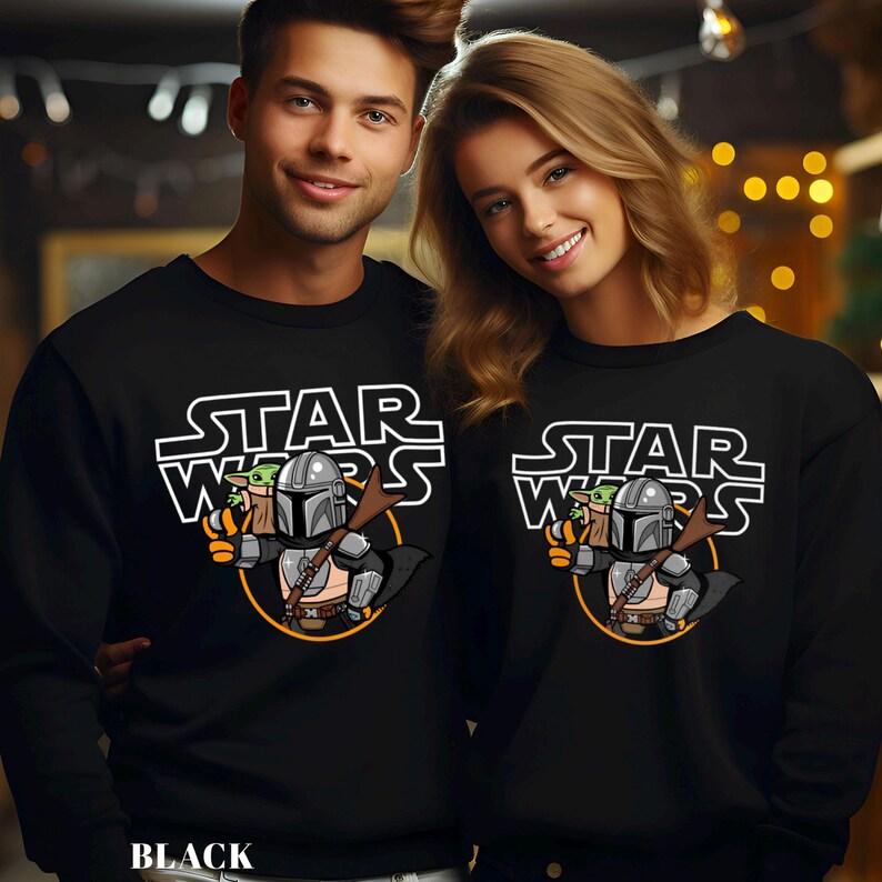 May include: Black sweatshirts with a Star Wars graphic featuring The Mandalorian and Grogu. The design includes the words "STAR WARS" in white block letters above an illustration of the characters. The word "BLACK" is printed at the bottom.