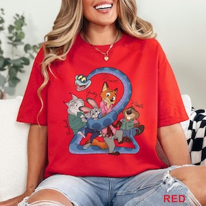 Puede incluir: Una camiseta roja de manga corta con un estampado gr&aacute;fico de personajes de dibujos animados, incluyendo un zorro, un conejo, un lince, un castor y una serpiente azul. El dise&ntilde;o incluye nombres escritos a mano junto a cada personaje.