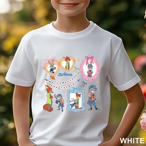 Pode incluir: Camiseta branca com ilustra&ccedil;&otilde;es coloridas de personagens do filme de anima&ccedil;&atilde;o Zootopia. O design inclui o texto "Welcome to Zootopia" e retratos de personagens emoldurados. A camiseta &eacute; feita de material macio.
