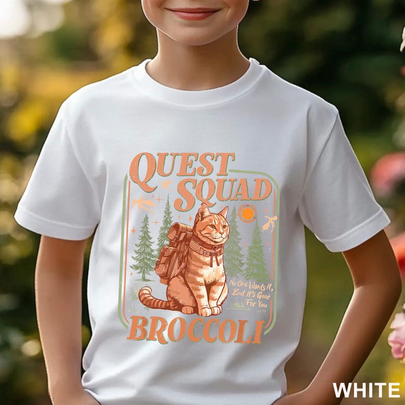 May include: White t-shirt featuring a cartoon cat with a backpack, the words "QUEST SQUAD BROCCOLI", and the phrase "No One Wants It, But It's Good For You". The design includes trees and a sun.